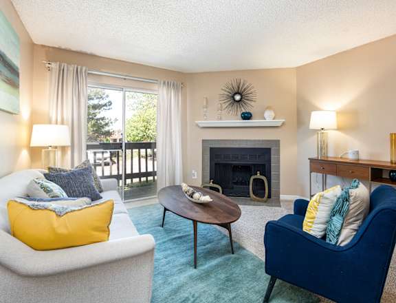 A living room with a fireplace and a blue armchair.