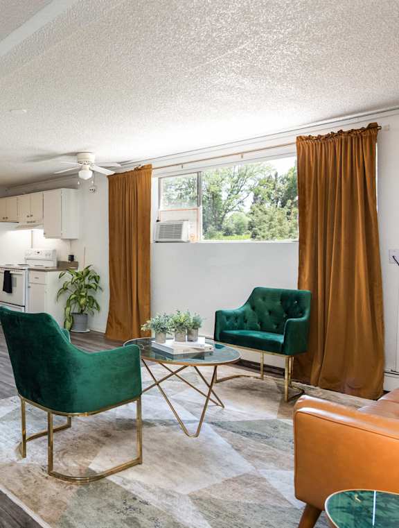 a living room with green chairs and a table