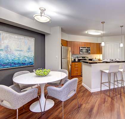 A kitchen with a dining table and chairs.