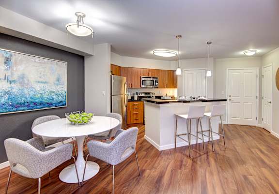 A kitchen with a dining table and chairs.