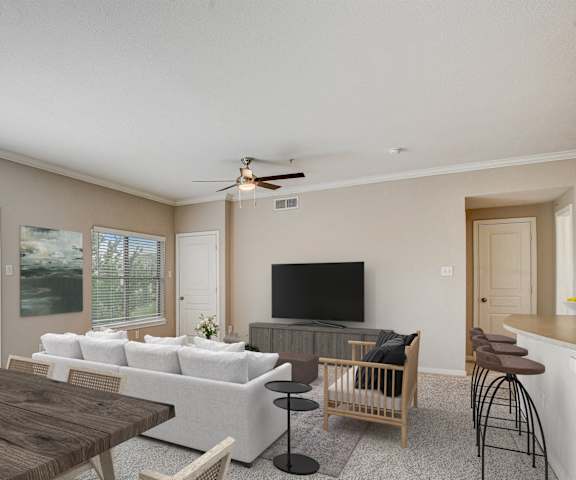 an open living room and dining room with a couch and a table at Artisan Apartments & Shops, Austin, 78729