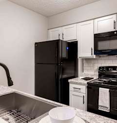 a kitchen with black appliances and granite counter tops