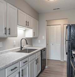 a kitchen with marble counter tops and white cabinets