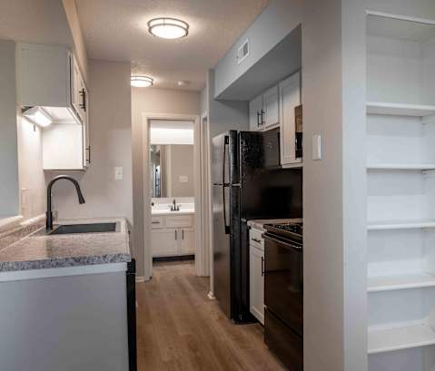 a renovated kitchen with black appliances and white cabinets