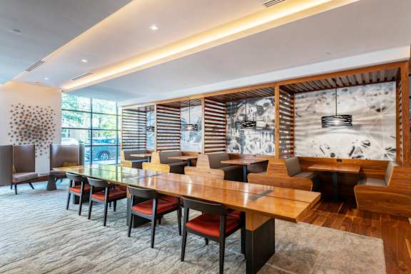 A long wooden table with chairs around it.