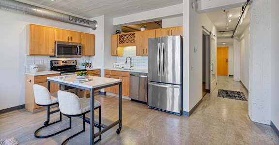 A kitchen with a table and chairs and a refrigerator.