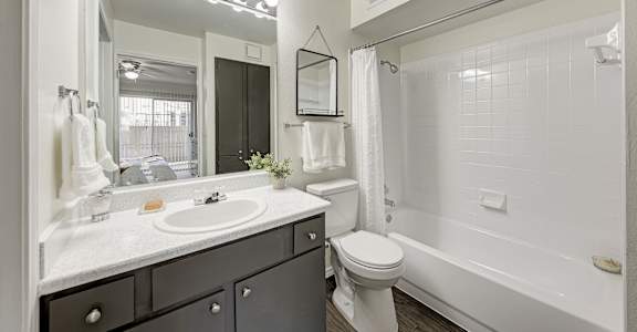 A bathroom with a sink, mirror, and towel rack.