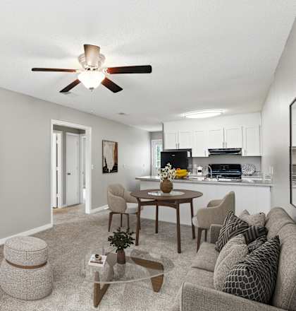 A living room with a grey couch, a coffee table, and a ceiling fan.