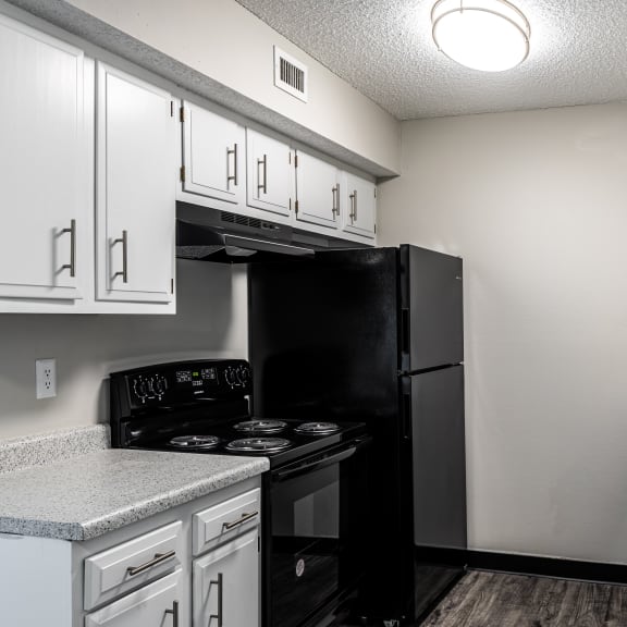 a kitchen with white cabinets and black appliances