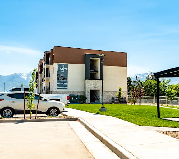 a picnic area with a grill and a building with mountains in the background