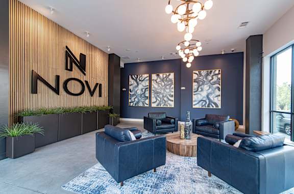 A modern living room with a large sofa set and a wooden wall with the letters "N" and "NOVI" on it.