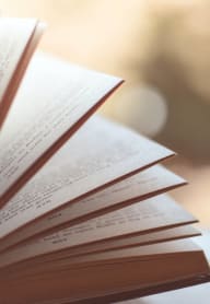 a stack of open books on a table