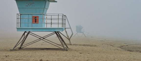 a lifeguard tower on the beach in the fog