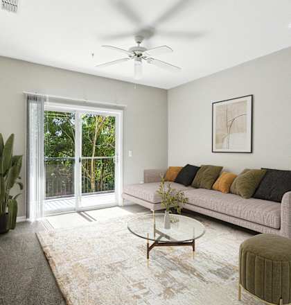 A living room with a couch, a coffee table, and a ceiling fan.