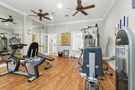 A gym with a treadmill, exercise bike, and other equipment.