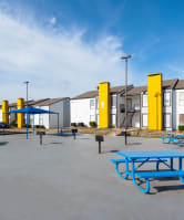 an empty playground with picnic tables and playground equipment at an elementary school