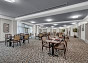 Thumbnail 5 of 54 - A large room with tables and chairs is set up for a meeting or event.