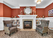 Thumbnail 7 of 54 - A living room with a fireplace and two chairs.
