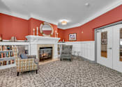 Thumbnail 9 of 54 - A living room with a fireplace and a chair.
