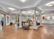 Thumbnail 14 of 54 - A spacious lobby with a wooden floor and a large chandelier.