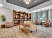 Thumbnail 15 of 54 - A living room with a carpeted floor and a bookshelf filled with books.