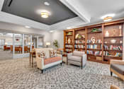 Thumbnail 16 of 54 - A living room with a couch, chairs, and a bookshelf.