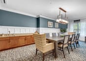 Thumbnail 18 of 54 - A dining room with a wooden table and chairs.