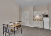 Thumbnail 20 of 54 - A kitchen area with a table and chairs.
