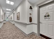 Thumbnail 26 of 54 - A hallway with a door on the right that has a sign on it.