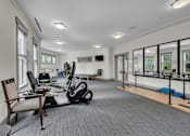 Thumbnail 51 of 54 - A spacious gym with a variety of equipment including a treadmill, exercise bike, and a bench.