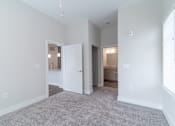 Thumbnail 7 of 8 - A spacious room with a carpeted floor and white walls.