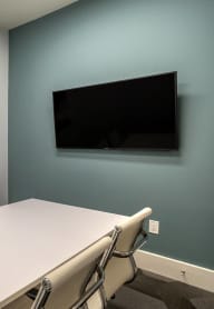 a conference room with a table and a tv on the wall