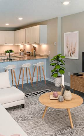 A modern living room with a white sofa, wooden coffee table, and a television.