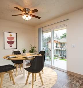 A dining room with a round table and chairs.