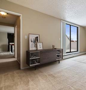 A bedroom with a large bed and a window overlooking a tree.