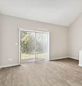 the living room of an empty apartment with a sliding glass door