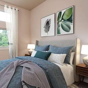 a bedroom with a bed with pillows and a comforter and a window