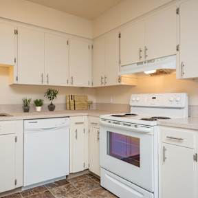 A kitchen with white appliances and cabinets.