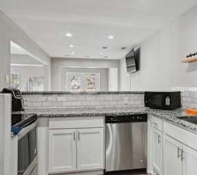 the kitchen has stainless steel appliances and granite counter tops