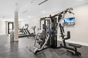a gym with exercise equipment and a flat screen tv