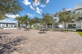 a courtyard with trees and a building in the background