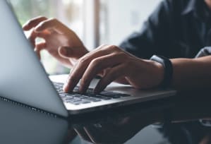 a person typing on a laptop computer