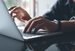 a person typing on a laptop computer