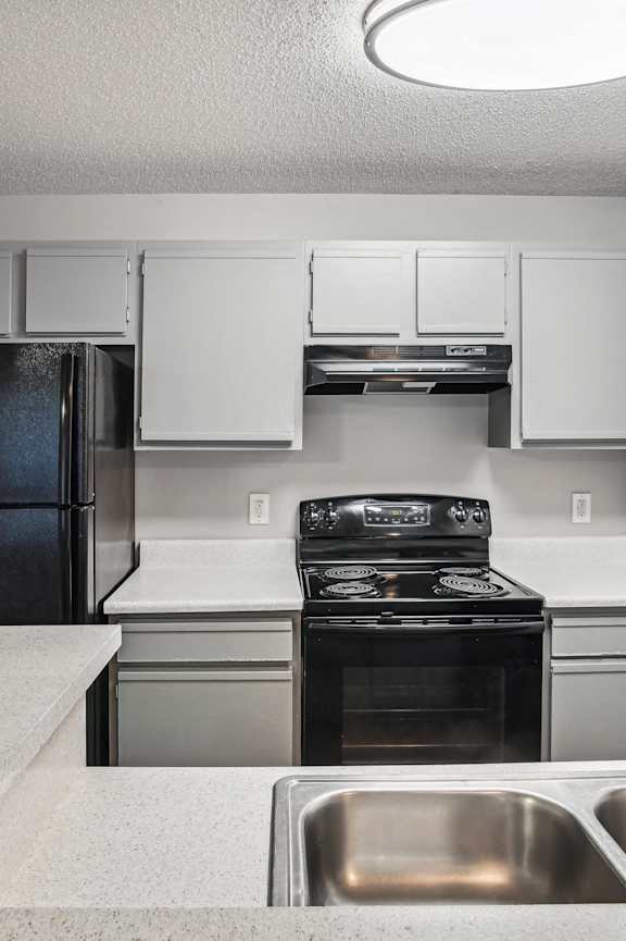 a kitchen with black appliances and brown cabinets  at Wellington Farms, North Carolina