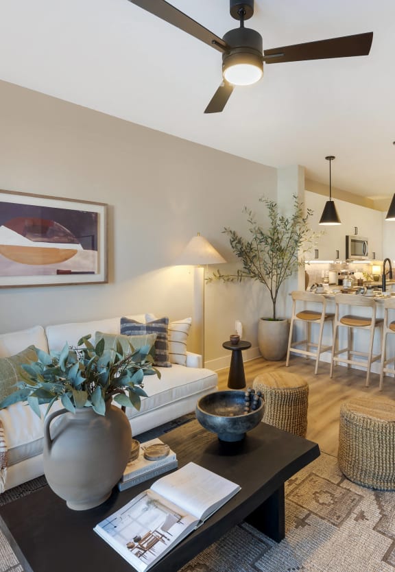 a living room with a couch and a table in front of a kitchen