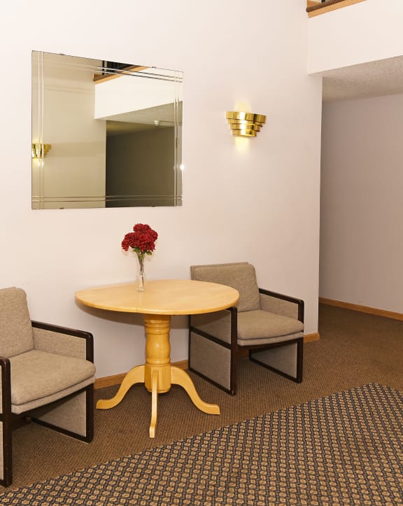 a room with a table and three chairs in front of a mirror