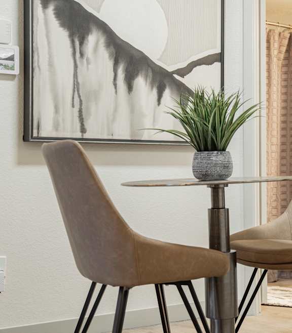 Two chairs and a table with a plant on it.
