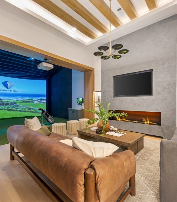 a living room with a couch and a tv and a view of the golf course