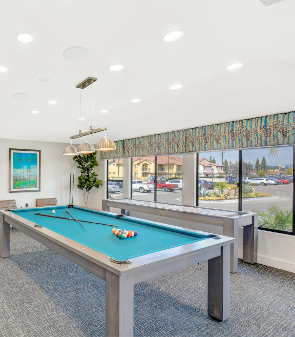 a games room with a pool table and a television