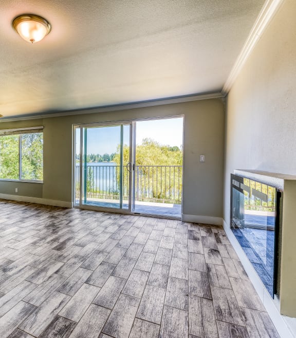 an empty living room with sliding glass doors to a balcony